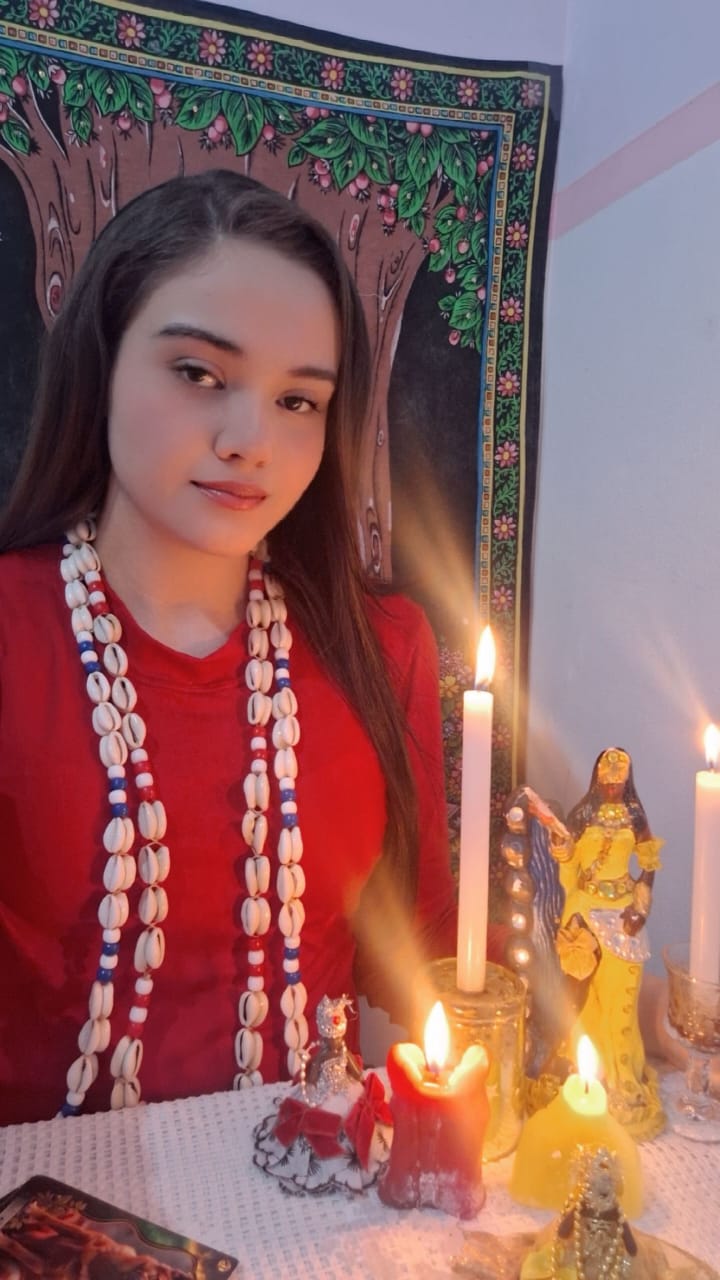 Taróloga Jordana em atendimento com cartas e velas